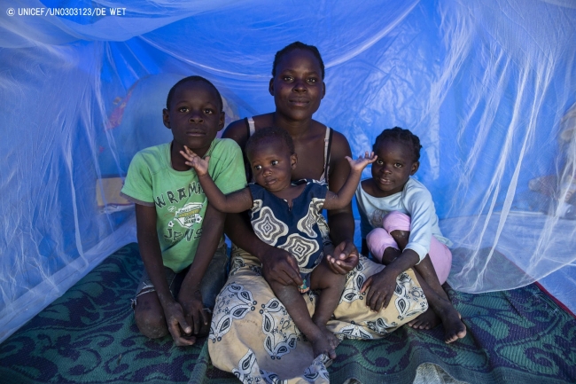 6人が滞在する避難先のテントで、蚊帳の中に座る家族。(2019年4月22日撮影) © UNICEF_UN0303123_DE WET