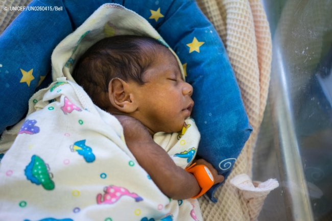 低体温時に呼び鈴がなる機器を着けて眠るパプアニューギニアの赤ちゃん。© UNICEF_UN0260415_Bell