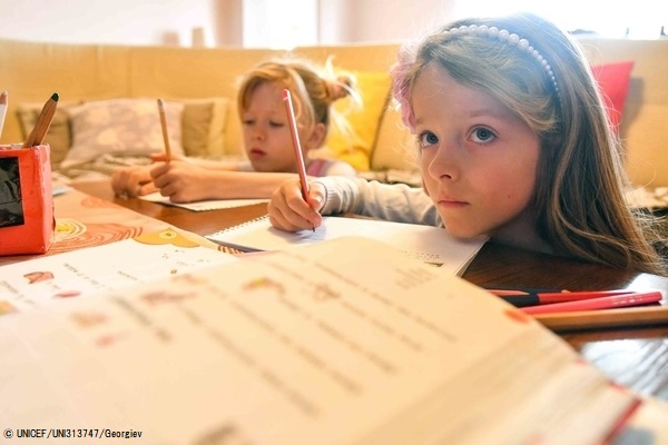 10日から学校が休校となっている北マケドニアで、テレビ教室プログラムを通して自宅で勉強する7歳のアナさんとカヤさんの双子の姉妹。(2020年3月24日撮影) © UNICEF_UNI313747_Georgiev