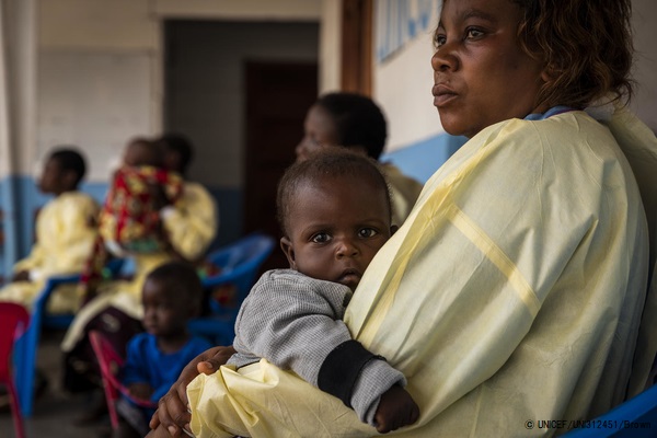 マンジナにあるユニセフが支援する保育所で、エボラ出血熱に感染した母親を持つ子どもを抱くスタッフ。(2020年1月20日撮影) © UNICEF_UNI312451_Brown