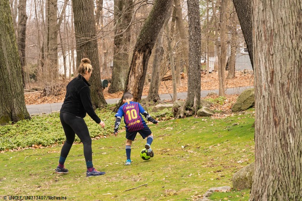 米国・コルチカット州で、遠隔授業の合間に母親とサッカーをする男の子。(2020年3月19日撮影) © UNICEF_UNI313407_McIlwaine