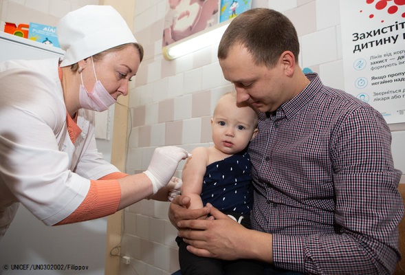 キエフ中心部にある総合病院で、はしか、おたふく風邪、風疹の混合ワクチンを受ける1歳のデイビットちゃん。(ウクライナ、2019年4月撮影) © UNICEF_UN0302002_Filippov