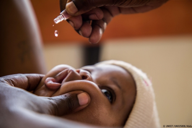 ポリオの予防接種を受けるナジブちゃん。COVID-19のロックダウンが続く中、息子を守るために予防接種を受けさせにきたと母親は話す。(ウガンダ、2020年4月撮影) © UNICEF_UNI325806_Abdu