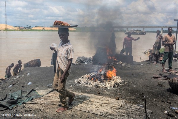 バイエルサ州・イェナゴアで、ゴムなどの廃棄物を燃やして発生した有害な煙の中を歩く男の子。(ナイジェリア、2016年10月撮影) ※本文との直接の関係はありません © UNICEF_UN037170_Bindra