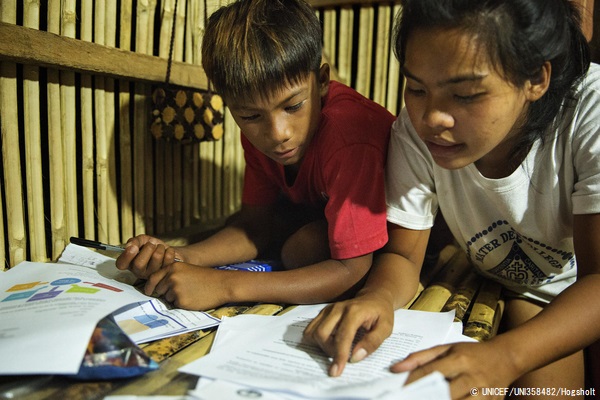 先生から毎週送られてくる宿題を姉のアリッサさん(右、20歳)に見てもらうアレンくん(左、13歳)。(フィリピン、2020年8月10日撮影) © UNICEF_UNI358482_Hogsholt