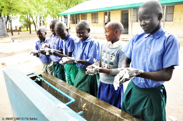 西ナイル地方のアジュマニ県にある小学校で、日本政府の支援を受けてユニセフが設置した水道で手を洗う子どもたち。 (ウガンダ、2020年3月撮影) © UNICEF_UNI315179_Adriko