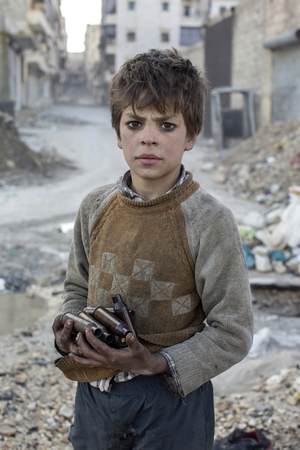 9歳のアラジンは、金屑として売るための空薬莢を集めている。2014年3月、シリア・アレッポにて撮影。© Niclas HammarstrÖm
