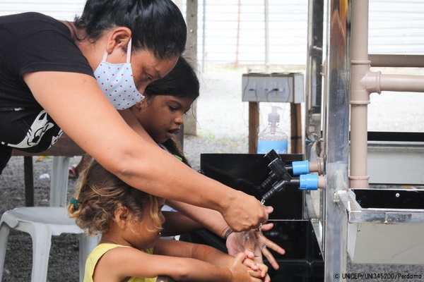 ロライマ州にある非公式居住区で、ユニセフが設置した新しい手洗い場を利用するベネズエラ難民の子どもと女性。(ブラジル、2020年5月撮影) © UNICEF_UNI345200_Perdomo