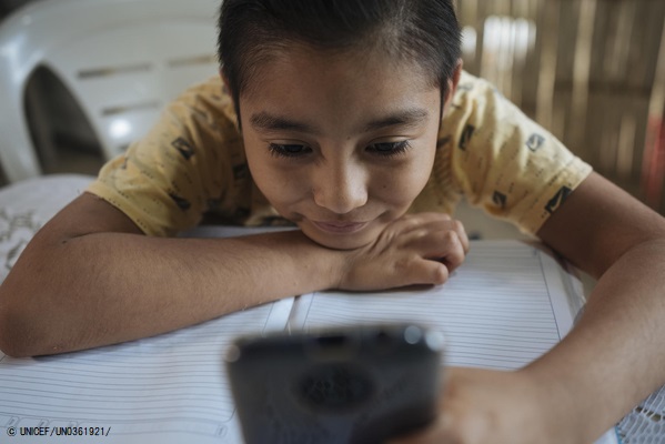COVID-19によって対面授業が中断されオンライン授業になり、携帯電話で宿題を確認する9歳のイスラエルくん。(エクアドル、2020年8月撮影) © UNICEF_UN0361921_