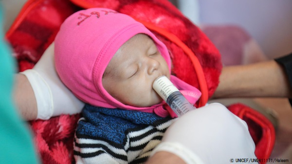 すぐに食べられる栄養治療食(RUTF)を口にする生後3カ月のサクルちゃん。今は回復しつつある。(2020年12月撮影) © UNICEF_UN0411171_Haleem
