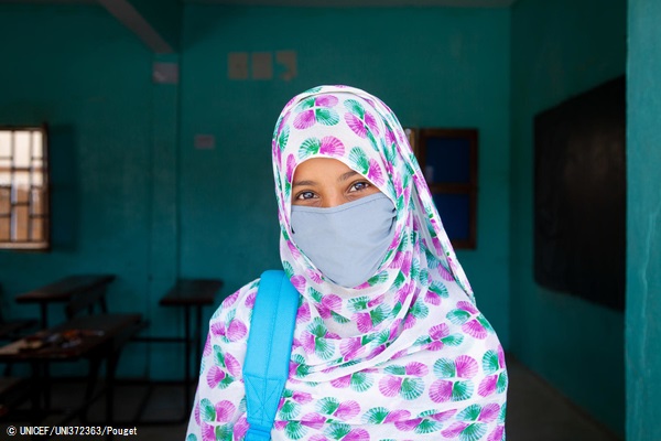 マスクを着用し、教室の前に立つ小学6年生の女の子。COVID-19の影響で数カ月の間、休校していた学校が再開し、テストを受けることができた。(モーリタニア、2020年9月撮影) © UNICEF_UNI372363_Pouget