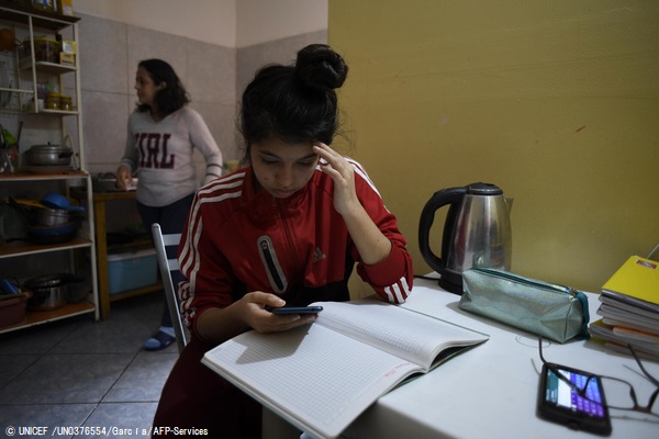 首都リマの自宅で宿題に取り組む15歳のダニエラさん。パソコンが自宅にないため、携帯アプリを通じて授業の映像を受信している。(ペルー、2020年9月撮影) © UNICEF_UN0376554_García_AFP-Services