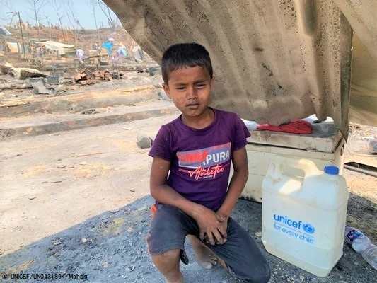 キレイな水が入ったユニセフのボトルを受け取り、家族の帰りを待つモハマドくん。(2021年3月23日撮影) © UNICEF_UN0431894_Mohsin