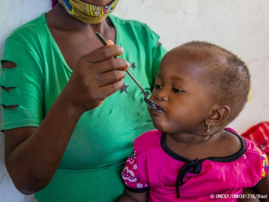 カボ・デルガド州のイボ島にある保健センターで、すぐに食べられる治療食(RUTF)を口にする中度の急性栄養不良の1歳のローザちゃん。(2020年12月撮影) © UNICEF_UN0381276_Bisol