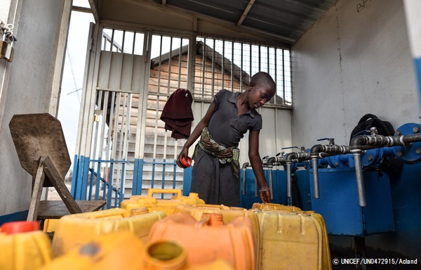 ゴマのバイパス配管システムによって供給された水を、水タンクに汲む女の子。(2021年6月4日撮影) © UNICEF_UN0472915_Acland