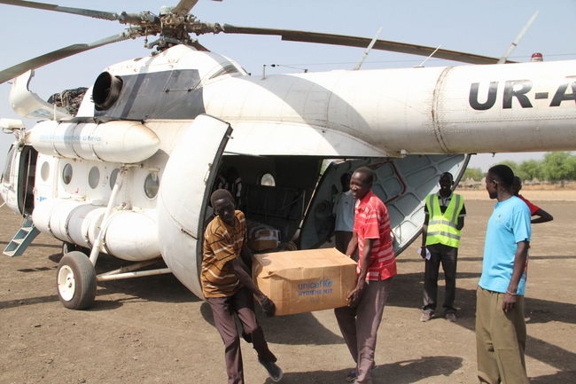 南スーダン・アコボで、ユニセフの緊急支援物資を運ぶボランティアスタッフ。©UNICEF/2014/Elder