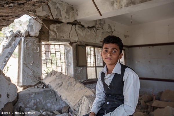 ハッジャ県にある破壊された学校の中で、瓦礫の上に座る12歳のアフメドくん。(2021年3月撮影) © UNICEF_UN0459558_Marish