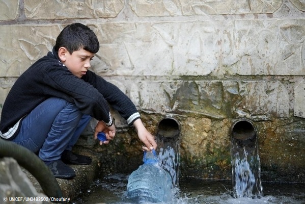 家族のために、村の井戸から汲み上げられた飲用水を容器に入れる11歳のアドハムくん。(2021年3月撮影) (C) UNICEF_UN0492502_Choufany