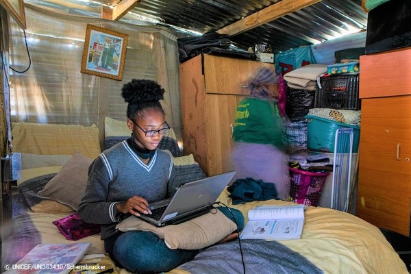 ヨハネスブルクの農村部にある非公式居住区の自宅で、ノートパソコンを使ってオンライン授業を受ける18歳の女の子。(2020年8月撮影) © UNICEF_UNI363430_Schermbrucker
