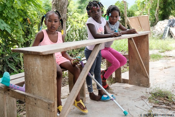 レカイ(Les Cayes)東部にある、地震の被害を受けた学校の隣のベンチに座る女の子たち。(2021年8月30日撮影) © UNICEF_UN0511432_Crickx