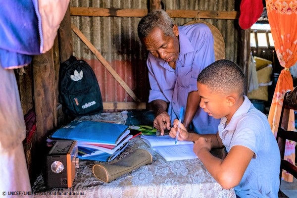 自宅で祖父に教えてもらいながら勉強する男の子。(カメルーン、7月撮影) © UNICEF_UN0542735_Andrianandrasana