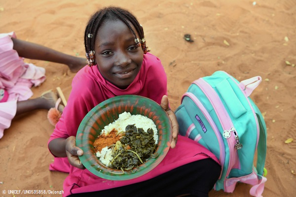 首都ニアメの学校で、給食を食べる7歳のジェミラさん。(ニジェール、2021年10月12日撮影) © UNICEF_UN0535858_Dejongh