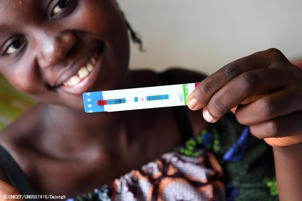 首都キンシャサの保健センターで、陰性のHIV検査結果を手に持つ妊娠5カ月目のデニースさん。 (コンゴ民主共和国、2021年8月撮影) © UNICEF_UN0507416_Dejongh