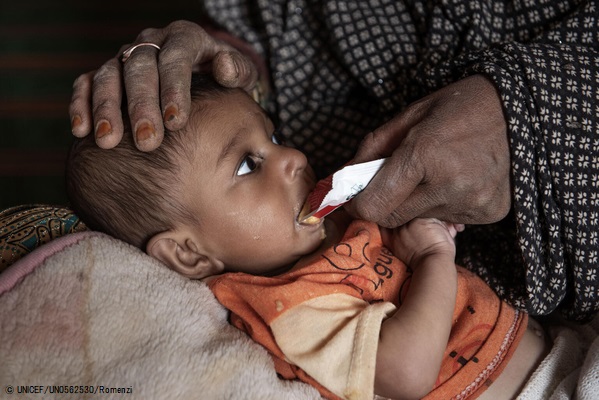 ユニセフが支援する移動式保健・栄養チームによる健康診断で、重度の急性栄養不良と診断され、すぐに食べられる栄養治療食(RUTF)を口にする生後9カ月のアフマドちゃん。(アフガニスタン、2021年11月18日撮影) (C) UNICEF_UN0562530_Rom