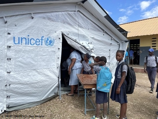 ユニセフの仮設テントの中に机を運ぶ子どもたち。(ハイチ、2022年2月撮影) (C) UNICEF_UN0590979_Diaz Mercado