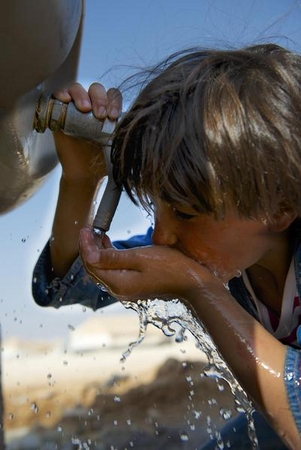 シリア国境付近にあるザータリ難民キャンプで水を飲む女の子© UNICEF/NYHQ2013-0667/Shehzad Noorani