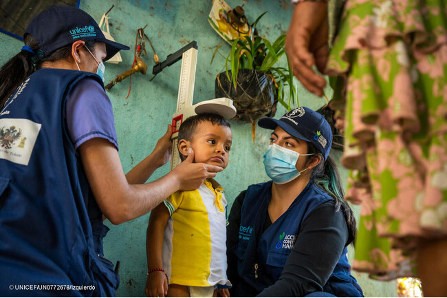 ユニセフが支援する移動式保健・栄養チームのスタッフに身長を測ってもらう2歳のハイメちゃん。移動式保健・栄養チームは遠隔地の村を訪れ、子どもたちの栄養状態の確認や予防接種のサービスを提供している。(グアテマラ、2023年1月撮影) (C) UNICEF_UN07