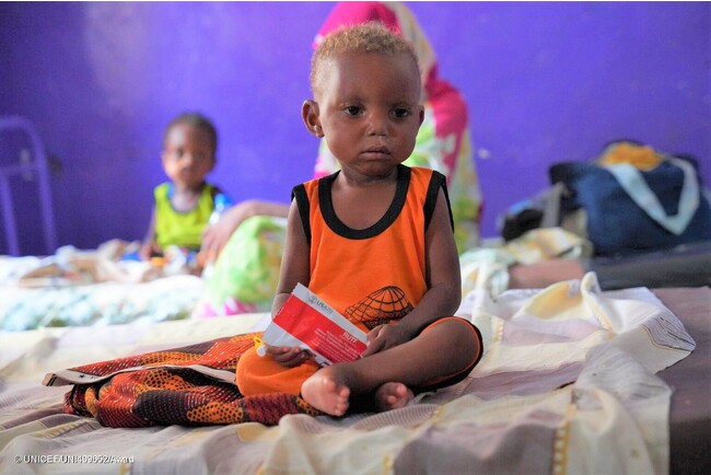 青ナイル州から逃れてきた重度の急性栄養不良で1歳のマフディーちゃん。避難先の小児科病院で、すぐに食べられる栄養治療食(RUTF)を受け取り、食欲検査を受けている。(スーダン、2023年7月3日撮影) (C) UNICEF_UNI409652_Awad