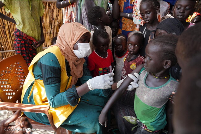 避難民キャンプで、はしかの予防接種を受ける子ども。病気が蔓延しやすい環境に置かれた子どもたちを守るため、ユニセフはスーダン全土で予防接種を行っている。(スーダン、2023年7月25日撮影) (C) UNICEF_UNI421906_Awad