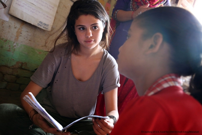 家族のために働かざるを得ない若者のための非公式学校での宿題を見せる女の子。©Courtesy of U.S. Fund for UNICEF/Josh Estey/MataHati
