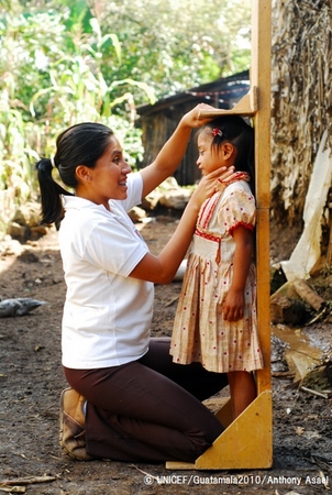 6歳の女の子の身長を測る看護師　© UNICEF/Guatamala2010/Anthony Asael