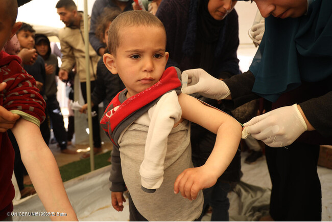 南部ラファにあるユニセフ支援の小児科のテントで、上腕計測メジャーで栄養状態をチェックされている3歳のアクラムちゃん。(ガザ地区、2024年2月15日撮影) (C) UNICEF_UNI519935_El Baba