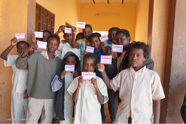 リバーナイル州の学校で、はしかと風しんの予防接種を受けた証明書を手に持つ子どもたち。(スーダン、2024年1月撮影) (C) UNICEF_UNI506599_Awad