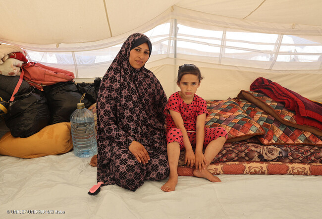ハンユニスからラファへ避難した7歳のロジーナさんと母親。「娘は多動症と診断されていますが、必要な治療を受けられていません」と母親は話す。(ガザ地区、2024年4月14日撮影) (C) UNICEF_UNI556614_El Baba