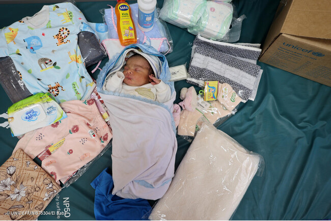 ユニセフから服やおむつなどの新生児に必要不可欠な物資を受け取った、生まれたばかりのウィダッドちゃんと母親。(ガザ地区、2024年4月29日撮影) (C) UNICEF_UNI575304_El Baba