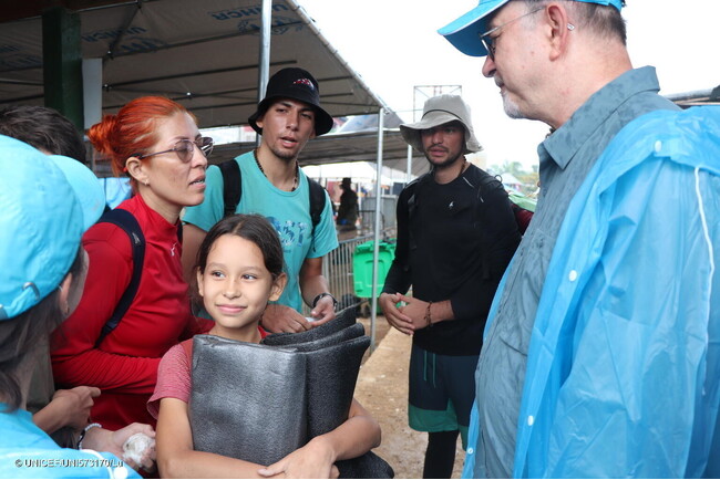 ダリエン地峡を横断し、バホ・チキートに到着した家族と話すチャイバン・ユニセフ事務局次長(右)。(パナマ、2024年4月24日撮影) (C) UNICEF_UNI573170_Lu
