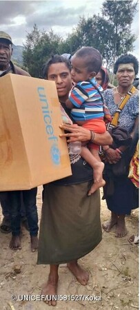 衛生用品などを含む、ユニセフの緊急支援物資を受け取る親子。(パプアニューギニア、2024年5月26日撮影) (C) UNICEF_UNI581527_Koka