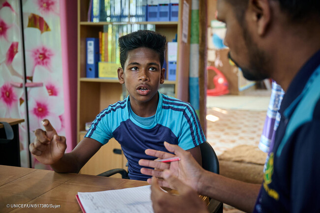 コックスバザールのロヒンギャ難民キャンプにある支援センターで、ケースワーカーと話す13歳のヌールさん。ヌールさんは家族から身体的虐待を受け、通っていた学習センターから連れ出されて働くことを強いられた。(バングラデシュ、2023年11月撮影) (C) UNICE