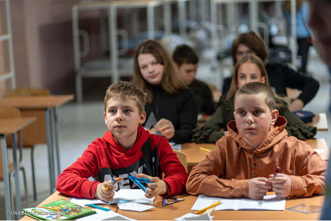 ハルキウにある学校の地下シェルターで授業を受ける12歳のイホールさん(左)。「2年間、自宅でオンライン学習をしていた分を取り戻すために、勉強しています」と話す。(ウクライナ、2024年3月撮影) (C) UNICEF_UNI575323_Filippov