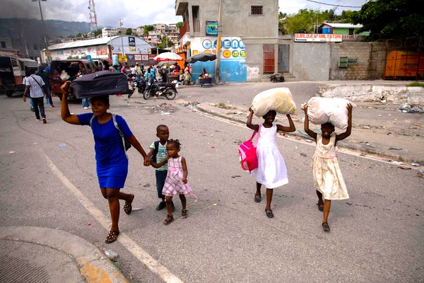 一晩中、自宅近くで銃撃戦があり、わずかな荷物を持って避難する家族。(ハイチ、2024年5月1日撮影) (C) UNICEF_UNI573342_Erol