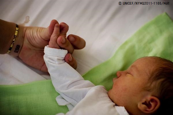 母親に手を握られながら眠る赤ちゃん（セルビア）© UNICEF/NYHQ2011-1165/Holt