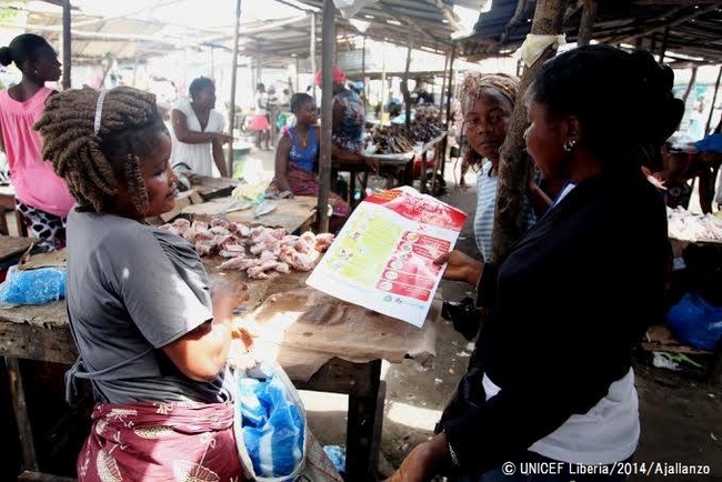多くの人が集まる市場で啓発活動を行うスタッフ。（リベリア）© UNICEF Liberia/2014/Ajallanzo