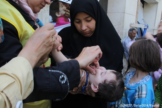 ユニセフとWHOの予防接種チームからポリオの予防接種を受ける女の子。©UNICEF/Syria-2014/Rashidi