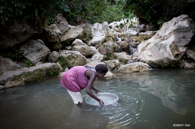 汚れた水源から水を汲む女性。©UNICEF Haiti