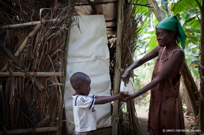 きれいな水で洗ってあげる母親。© UNICEF/UNI165185/Dormino