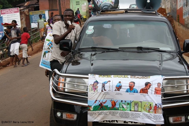車にエボラに関する公用情報ポスターを貼って町を巡り、予防法を広めるスタッフ。©UNICEF Sierra Leone/2014